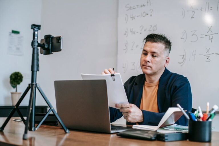Teacher running an online class with a laptop and camera